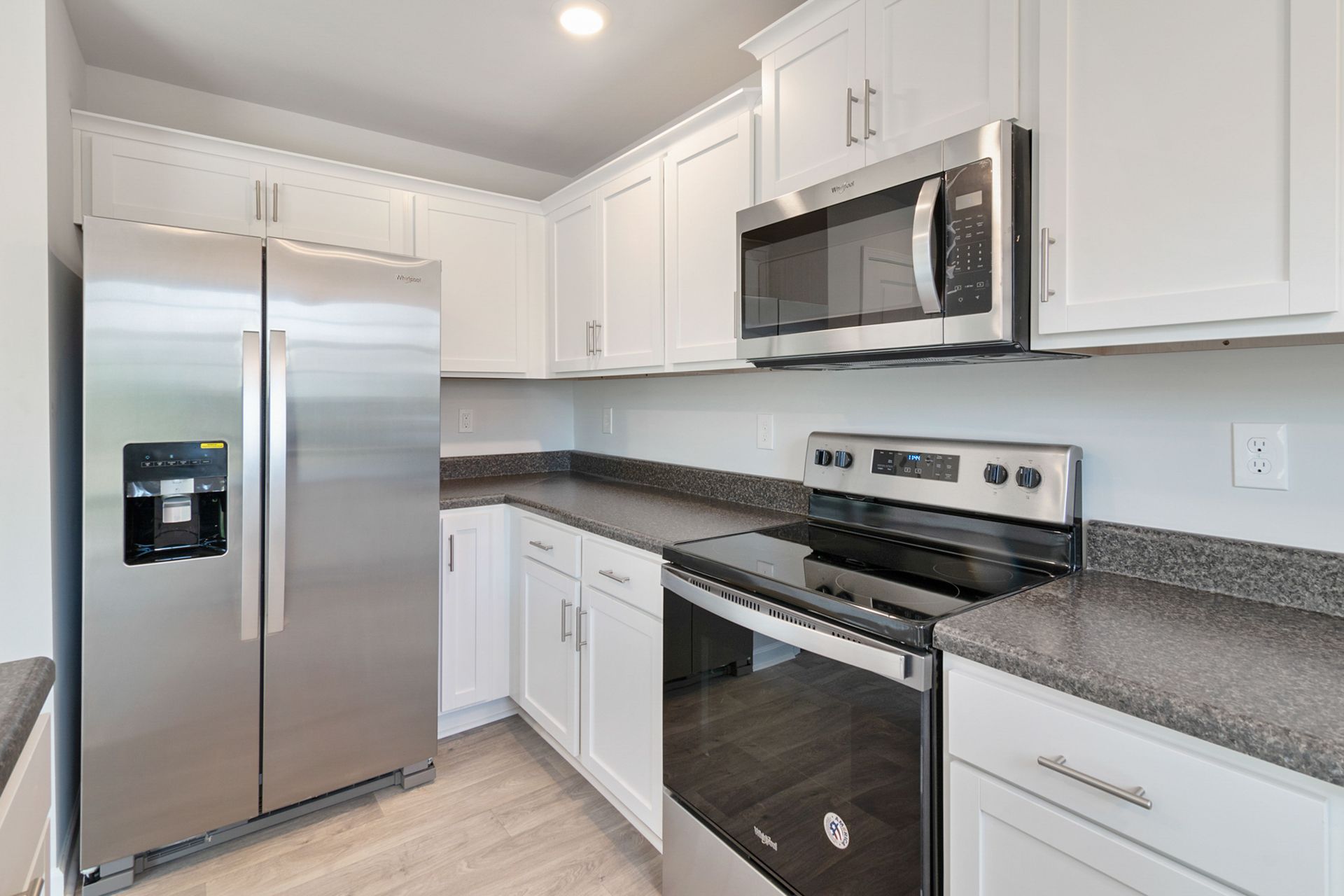 Sleek kitchen with stainless steel appliances and white cabinetry.